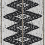 jacquard weave boasts a series of bold, interconnected diamonds in dark charcoal on neutral background
