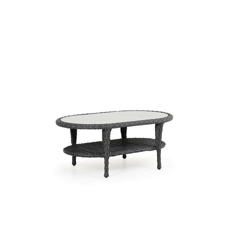 Outdoor woven oval cocktail table with glass top and woven shelf near bottom